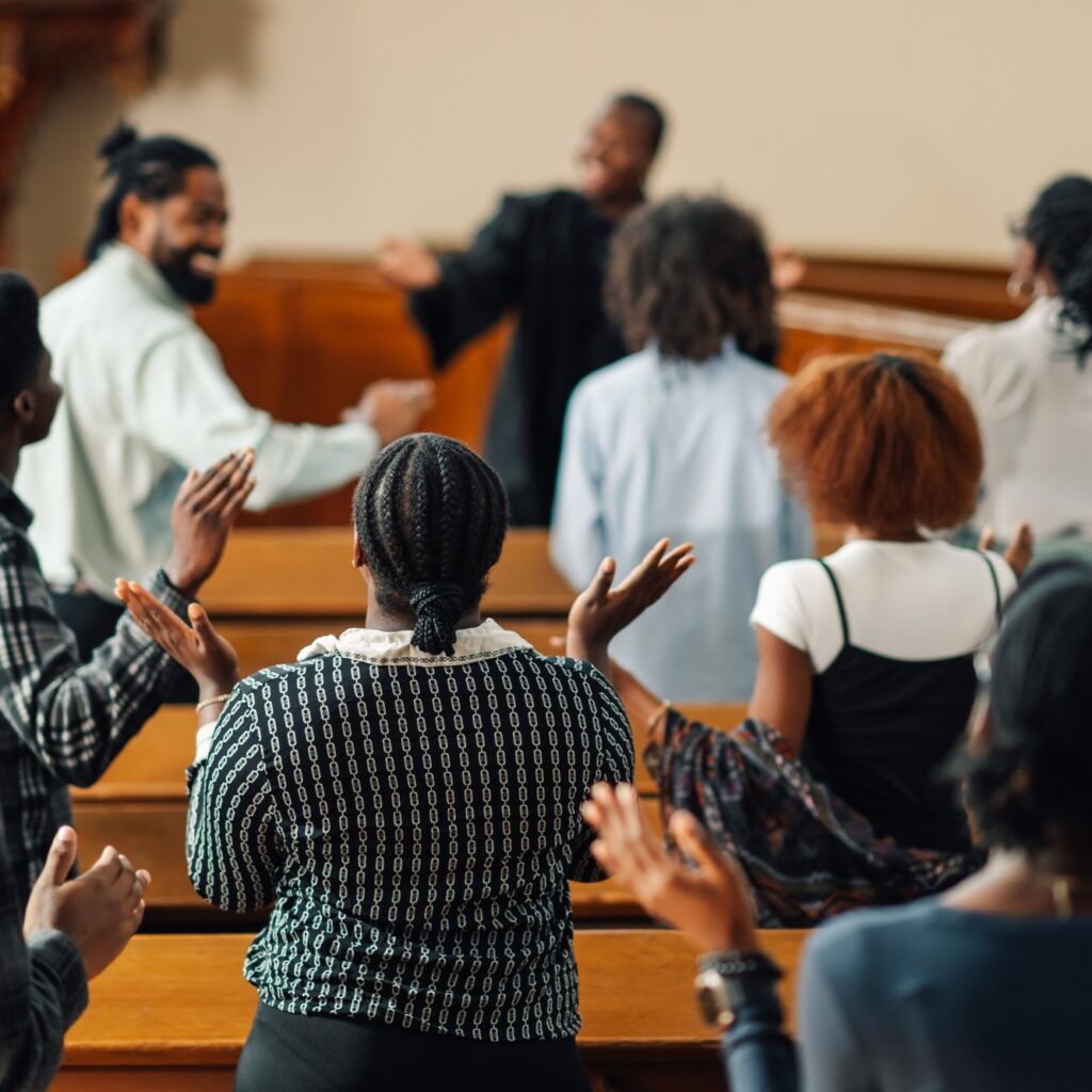 Group of people raising their hands while praying inside the church
