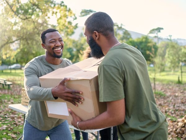 Black man, charity and holding box in park of donation, community service or social responsibility.