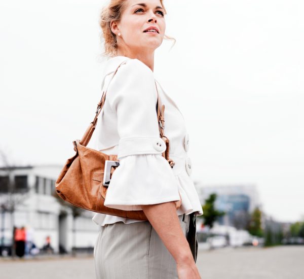 Confident woman with a purposeful gaze walking in the city