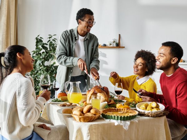 Friends joyfully celebrating Thanksgiving together with a bountiful feast at home