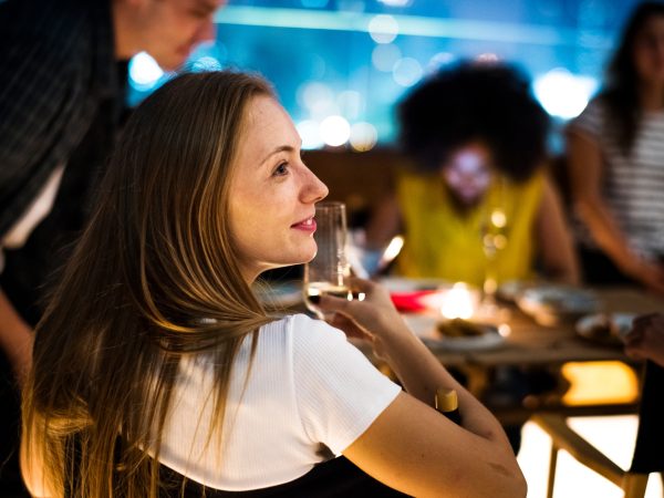Young adults dinner night with friends at a rooftop restaurant